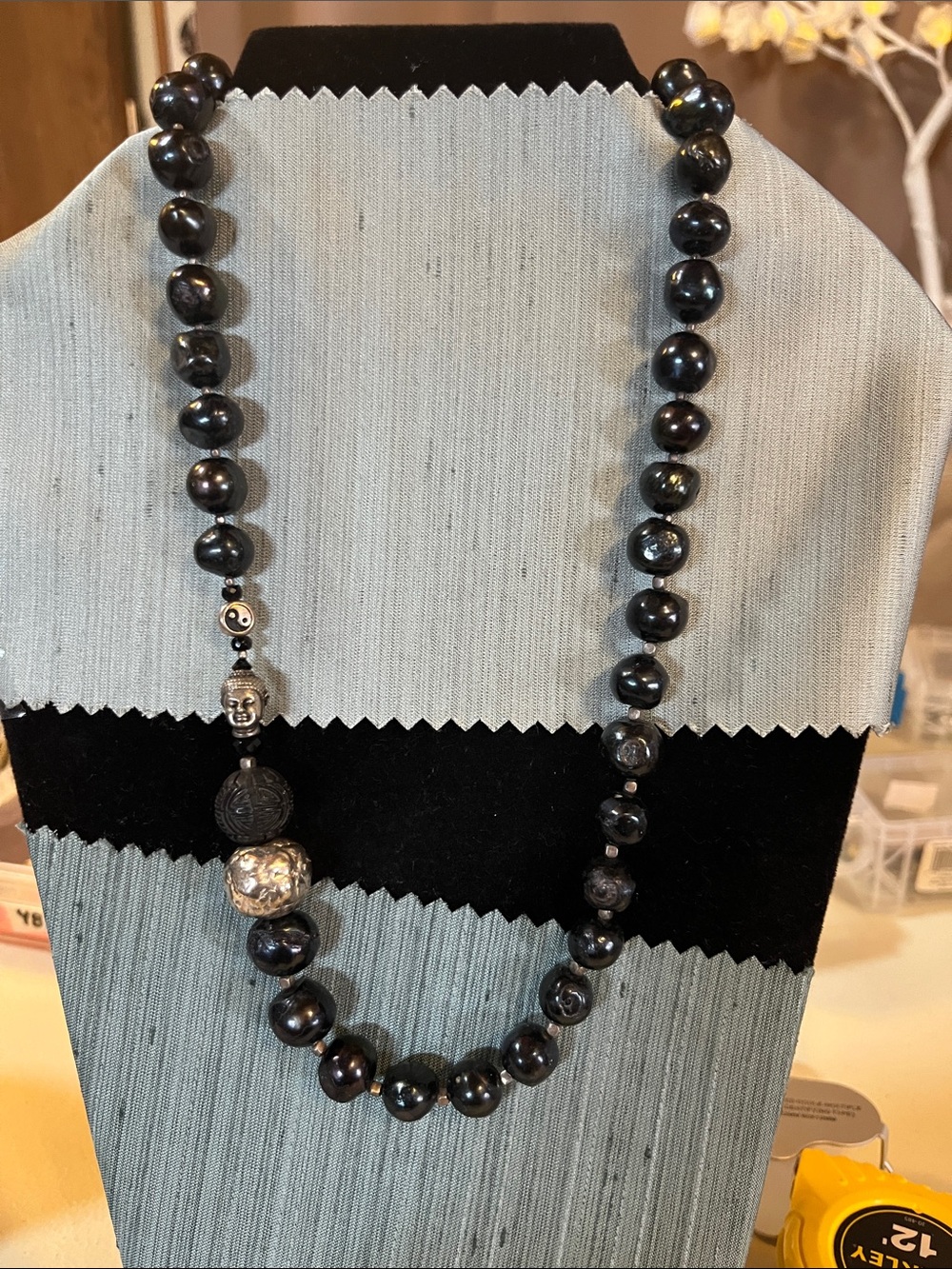 Black baroque style beads with Buddha charm. Clasp is spring ring marked 925.